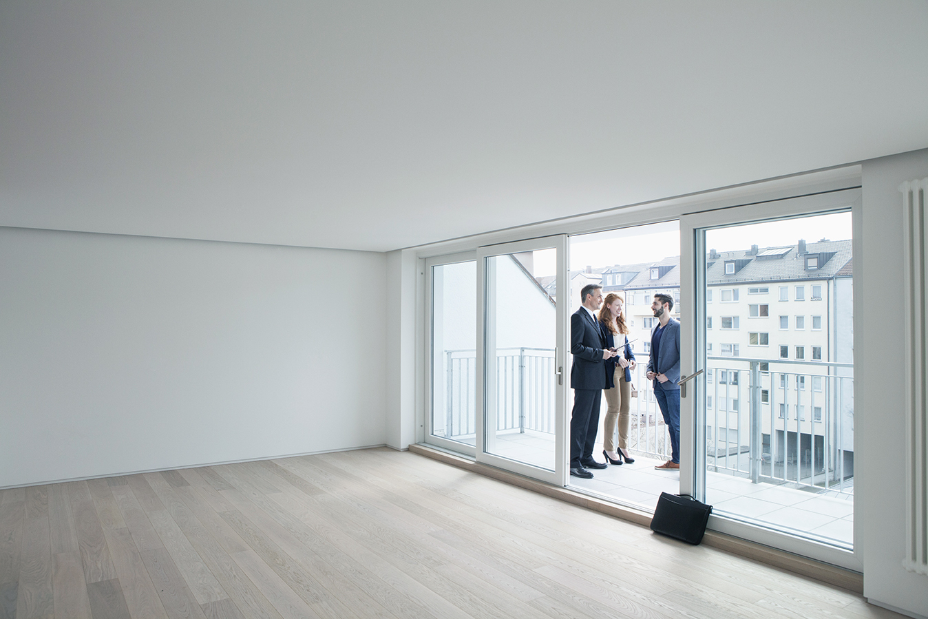 A real estate agent showing an apartment to a young couple